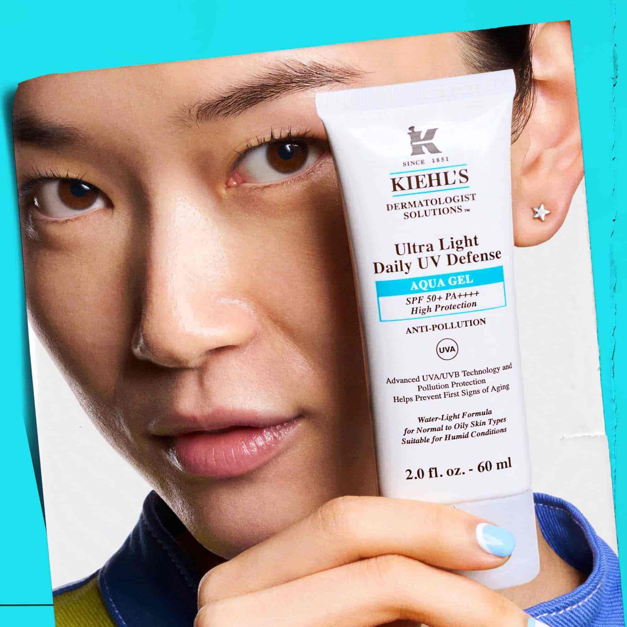 Modelka trzymająca tubkę żelu Ultra Light Daily UV Defense Aqua Gel, prezentująca poręczność i łatwość użycia.