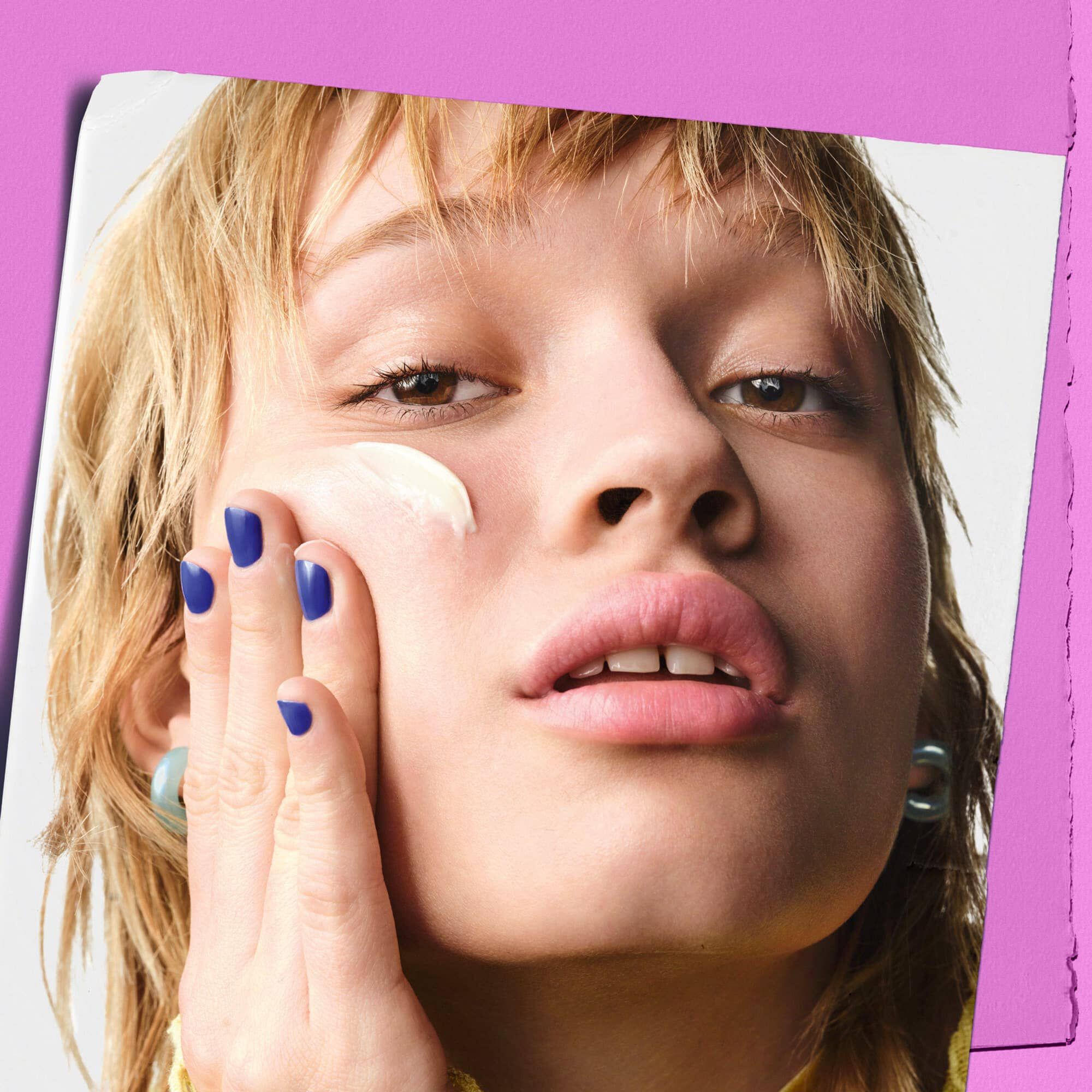 Modelka nakładająca krem Kiehl's Super Multi-Corrective Cream na policzek