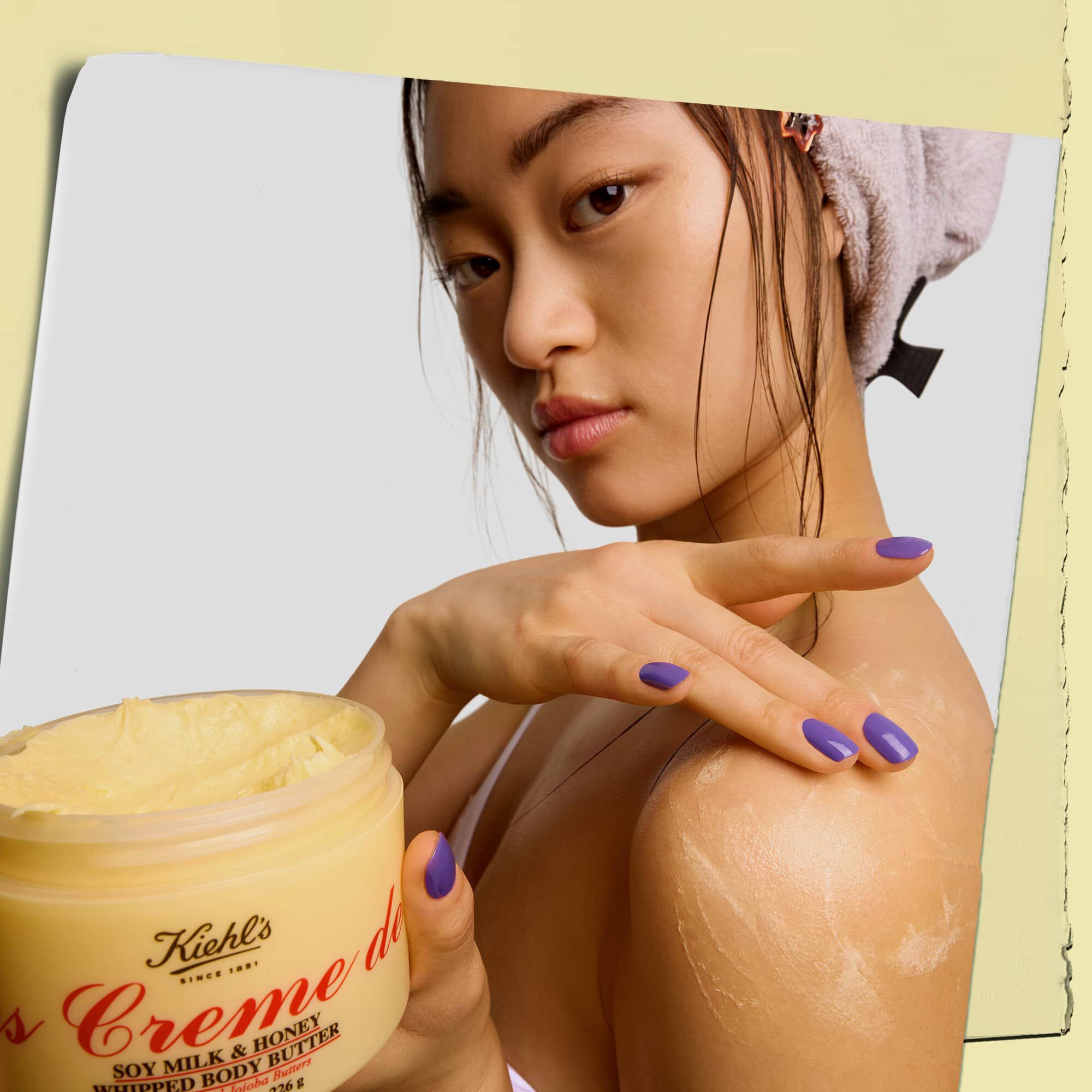 Modelka trzymająca słoiczek i nakładająca masło do ciała Kiehl's Creme de Corps Whipped Butter
