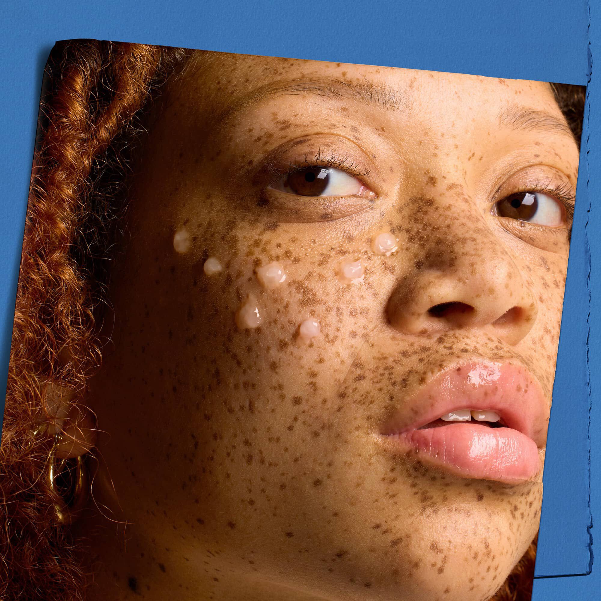 Modelka z kroplami koncentratu serum Kiehl's Hydro Plumping na twarzy