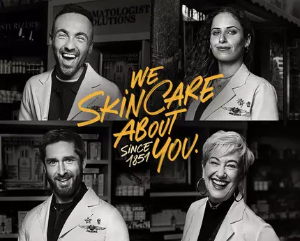 Trzech dermatologow w białych kitlach z uśmiechami, z tekstem „My dbamy o Twoją skorę od początku!” na tle połki z produktami do pielęgnacji skory.
