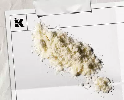 Kremowy proszek reprezentujący 1% Colloidal Oateal na białej tafli z czarnym logo Kiehl's w rogu.