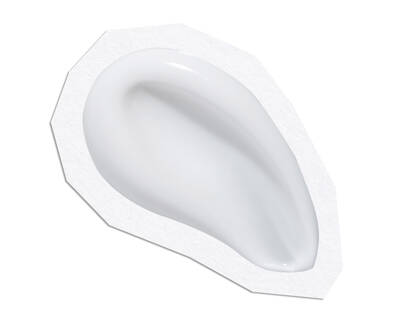 A smooth, white ear-shaped silicone mold on a flat surface with a slightly textured border.