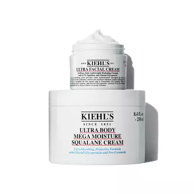 A container of Kiehl's Ultra Body Mega Moisture Squalane Cream and a smaller jar of Ultra Facial Cream, both featuring a clean, minimalist design with visible product labels.