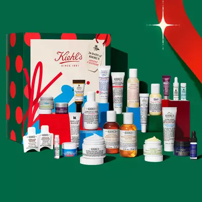 Świąteczny kalendarz adwentowy Kiehl's oraz zestaw prezentowy z produktami do pielęgnacji, zawierający zrożnicowane kremy, serum, płyny oczyszczające i kuracje, zaprezentowane na świątecznej ekspozycji.
