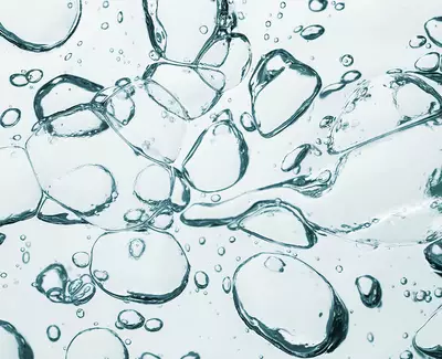 Close-up of transparent bubbles floating in a clear liquid, creating a sense of movement and depth.