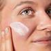 Kobieta nakładająca Kiehl’s krem przeciwsłoneczny na twarz SPF 50 PA ++++