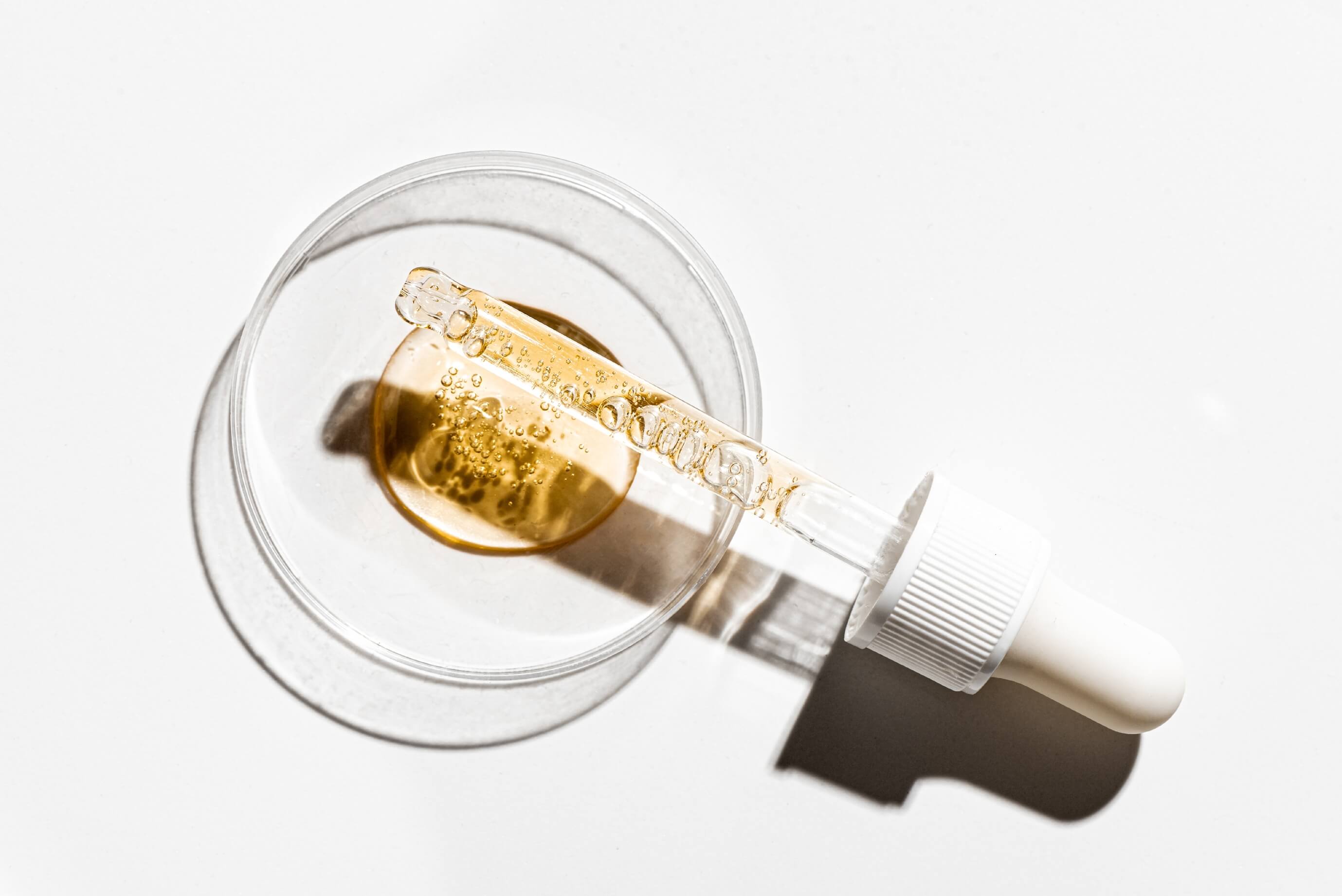 Pipetka z serum z  retinolem na tle szklanego wieczka